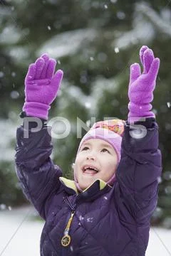 Asian girl with arms raised in snow Stock Photos