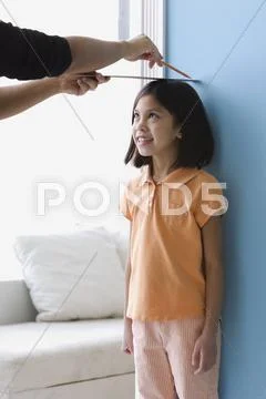 Asian girl having height measured on wall Stock Photos