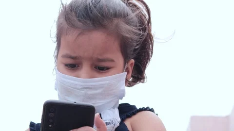 Asian Girl learning New things with phone under the open sky with mask on face Stock Footage 129226823