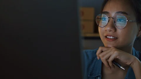 Asian girl looking at computer screen reflection in eyeglasses  at night Stock Footage 116033614