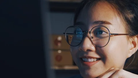 Asian girl looking at computer screen reflection in eyeglasses  at night Stock Footage 116036944