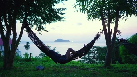 Asian Girl Napping on a Hammock between two trees at Sunset, Thailand. Stock Footage 153569167