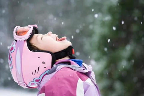 Asian girl sticking out tongue in snow Stock Photos