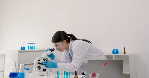 Asian girl student looking into microscope during primary school chemistry class Stock Footage 320668652