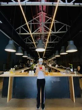 Asian girl teenage in cafe with symetric light wears a mask Stock Photos