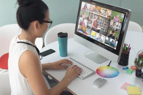 Asian girl using computer for video call, with smiling diverse elementary school Stock Photos