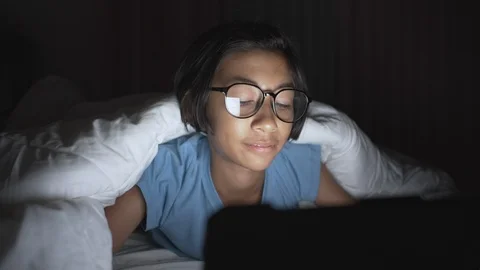 Asian girl using a tablet on a bed in her home Stock Footage 109519274