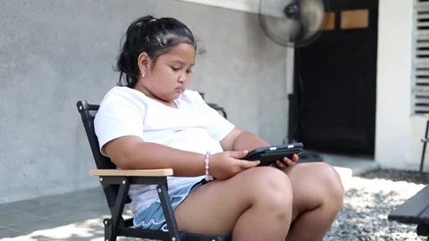 Asian girl using a tablet while sitting outdoors at home. digital learning Stock Footage 340838842