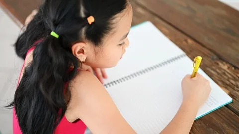 Asian girls write on paper at the table Stock Footage 117463459