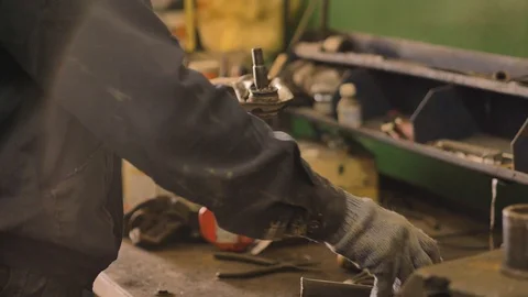 Asian in gloves and work clothes is repairing a spare part of a car in a garage Video stock 129833073