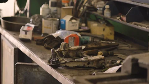 Asian in gloves and work clothes is repairing a spare part of a car in a garage Video stock 129834024