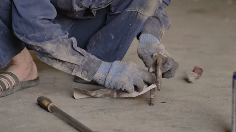 Asian in gloves and work clothes is repairing a spare part of a car in a garage Stock Footage 129840524