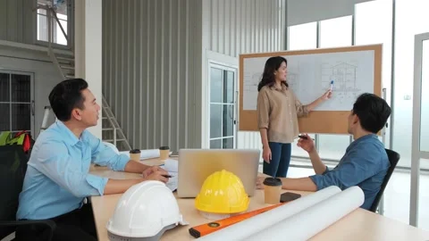 Asian group Architects working on plans with a blueprint Stock Footage 150474067