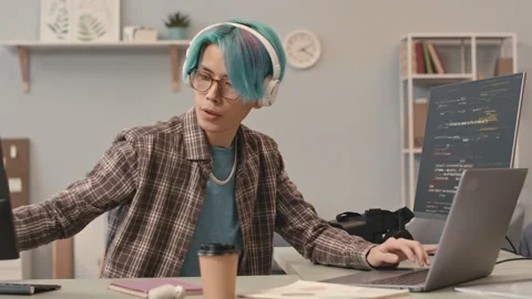 Asian Guy with Blue Hair Program Coding on Computer Stock Footage 241272384