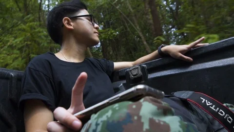Asian guy tapping for the beat of the song he listen in the forest. Focus Face. Stock Footage 107466498