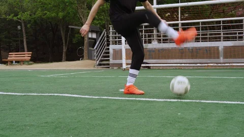 Asian guy trains with a soccer ball in the stadium Stock Footage