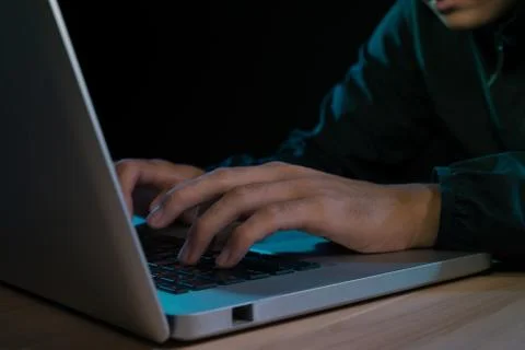 Asian hacker hacking computer network with laptop in dark. Cyber security con Stock Photos