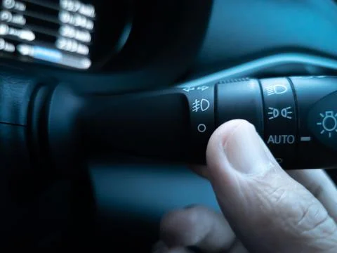 Asian hand (thumb), using turn on the high beam headlights. Фото