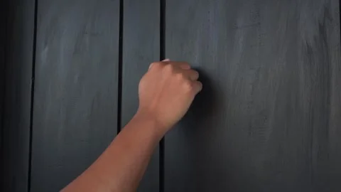 An Asian hand was knocking on the black door Stock Footage 337933564