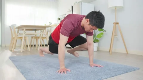 Asian handsome active young man doing push up on floor in living room. Stock Footage 171263734