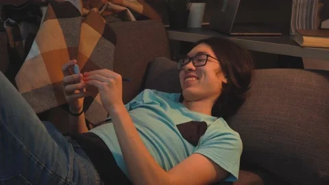Asian Handsome  Guy is  Laying on the Sofa Thinking about Idea Stock Footage 148347773
