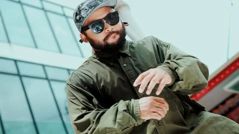 Asian hipster looking at camera while dancing at sky scrapper. Endeavor. Stock Photos