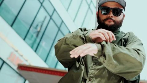 Asian hipster looking at camera while dancing at sky scrapper. Hiphop. Stock Photos