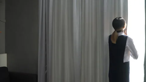 Asian housekeeper opening curtains of window in room . Chambermaid cleaning.. Stock Footage 242980955