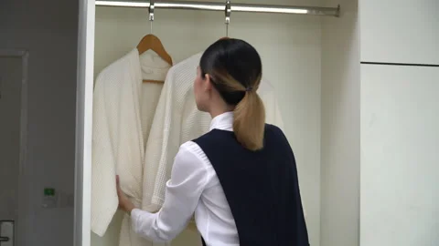 Asian housekeeper setting up Bathrobe in wardrobe . Chambermaid cleaning ho.. Stock Footage 242982373