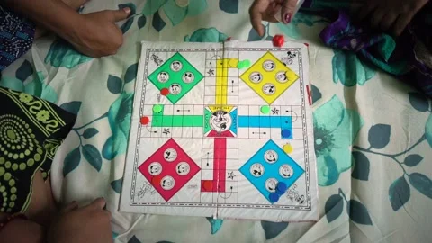 Asian Indian Family playing Ludo board game on bed at home, female hand Stock Footage