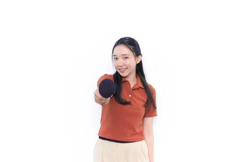 Asian Indonesian model singing using a mic wearing an orange shirt Stock Photos