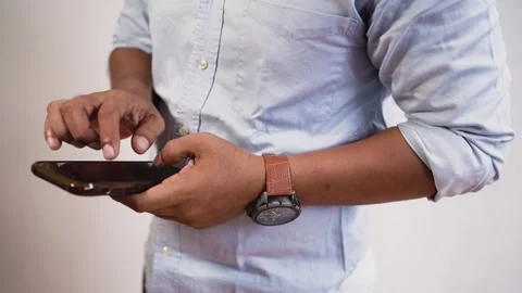 Asian Indonesian young man using apps on a touchscreen smartphone. Stock Footage 268772542