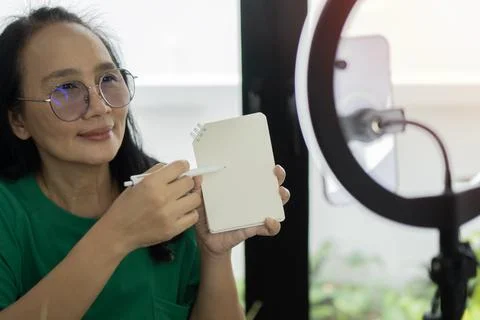 Asian influencer, sharing note tips and reviews, capturing creative videos .. Stock Photos