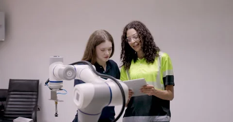 Asian instructor holding tablet while teaching young female trainee during Stock Footage 319476442