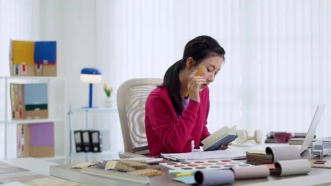 Asian interior designer selecting fabric samples planning furniture design .. Stock Footage 336484214
