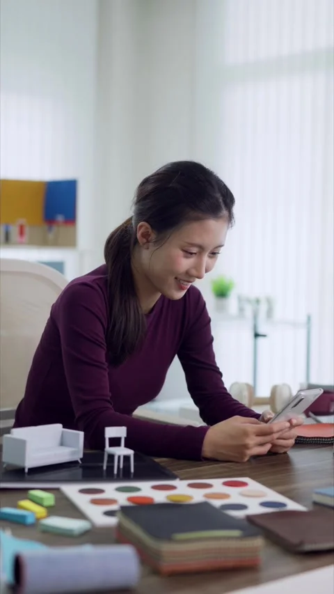 Asian interior designer using smartphone checking furniture design samples .. Stock Footage 336484373