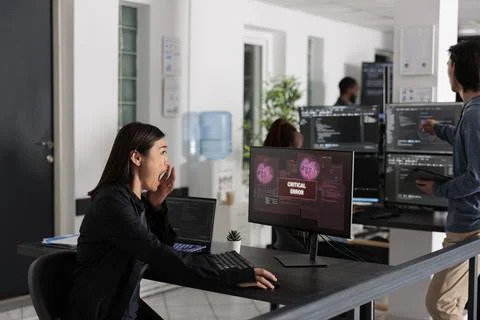 Asian it programmer reading critical errors on computer display 스톡 사진