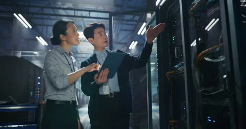 Asian IT Specialists Using Tablet Computer in Data Center 動画素材 320000877