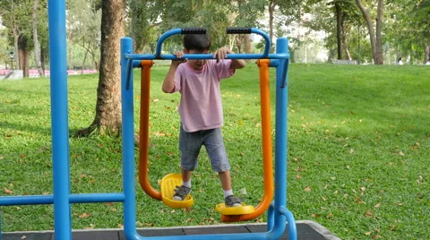 Asian kid boy exercise with walking equipment at outdoor fitness in public park 動画素材 62653237