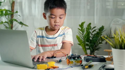 Asian kid boy learns coding and programming with laptop for Arduino robot car Stock Footage 200330622