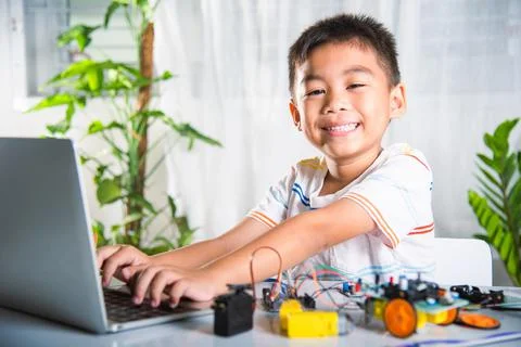 Asian kid boy learns coding and programming with laptop for Arduino robot car Stock-Fotos