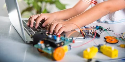 Asian kid boy learns coding and programming with laptop for Arduino robot car Stock-Fotos