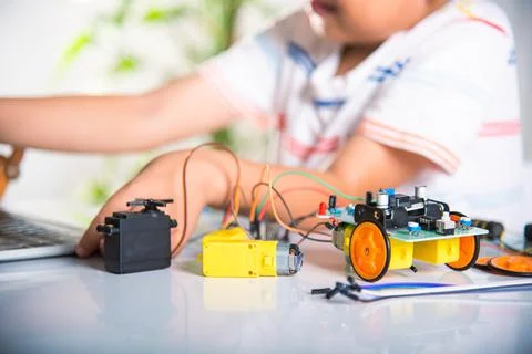 Asian kid boy learns coding and programming with laptop for Arduino robot car Stock-Fotos