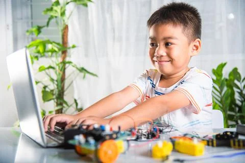 Asian kid boy learns coding and programming with laptop for Arduino robot car Stock-Fotos