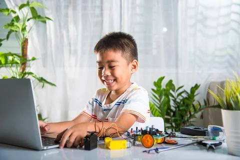 Asian kid boy learns coding and programming with laptop for Arduino robot car Stock-Fotos