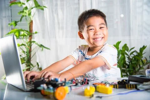 Asian kid boy learns coding and programming with laptop for Arduino robot car Stock-Fotos