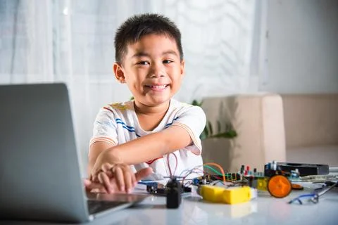 Asian kid boy learns coding and programming with laptop for Arduino robot car Stock Photos