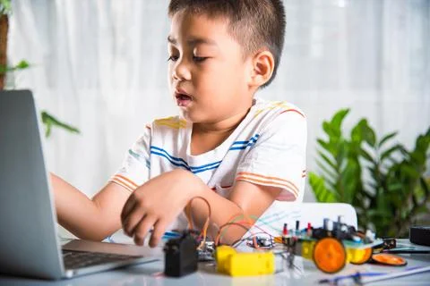 Asian kid boy learns coding and programming with laptop for Arduino robot car Stock-Fotos