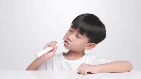 Asian kid brushing teeth with electric toothbrush. Stock Footage 197365659