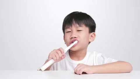 Asian kid brushing teeth with electric toothbrush. Stock-Footage 204724232